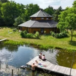 Ośmiokątny dom z gliny i słomy nad basenem naturalnym w agroturystyce Złoty Klon w Kijance